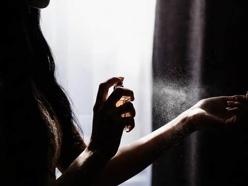 香水を手首に吹きかける女性